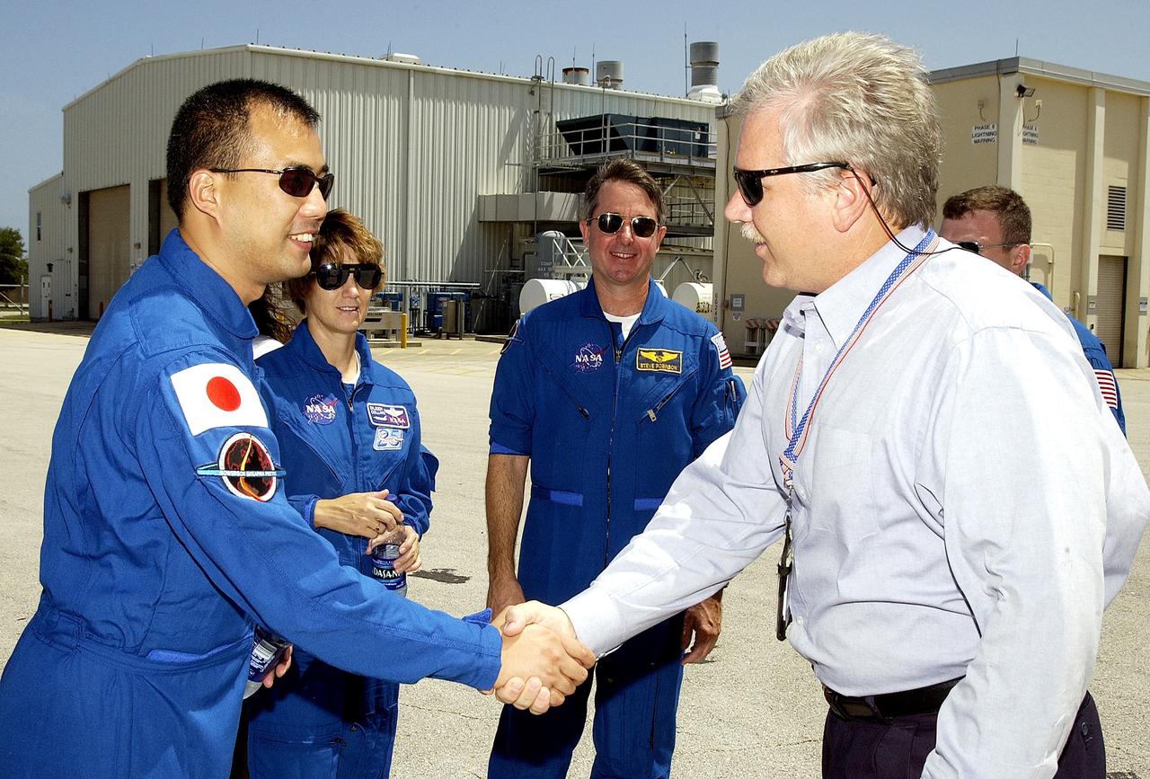 KENNEDY SPACE CENTER, FLA. -   The STS-114 crew is welcomed to Hangar AF, Cape Canaveral Air Force Station, by Joseph Chaput, with United Space Alliance. The crew, from left, are Mission Specialist Soichi Noguchi, Commander Eileen Collins, Mission Specialist Stephen Robinson and (partially hidden) Pilot James Kelly.  Noguchi is with the Japanese space agency NASDA.  On the mission, the crew will carry the MultiPurpose Logistics Module (MPLM) Raffaello and External Stowage Platform 2 to the International Space Station.  The MPLM will contain supplies and equipment.  Another goal of the mission is to remove and replace a Control Moment Gyro.  Launch date for mission STS-114 is under review.  Hangar AF is the site where SRB Retrieval Ships return the spent solid rocket boosters after a Shuttle launch.  The SRBs are lifted from the water and placed on rail cars to begin the disassembly and refurbishment process.