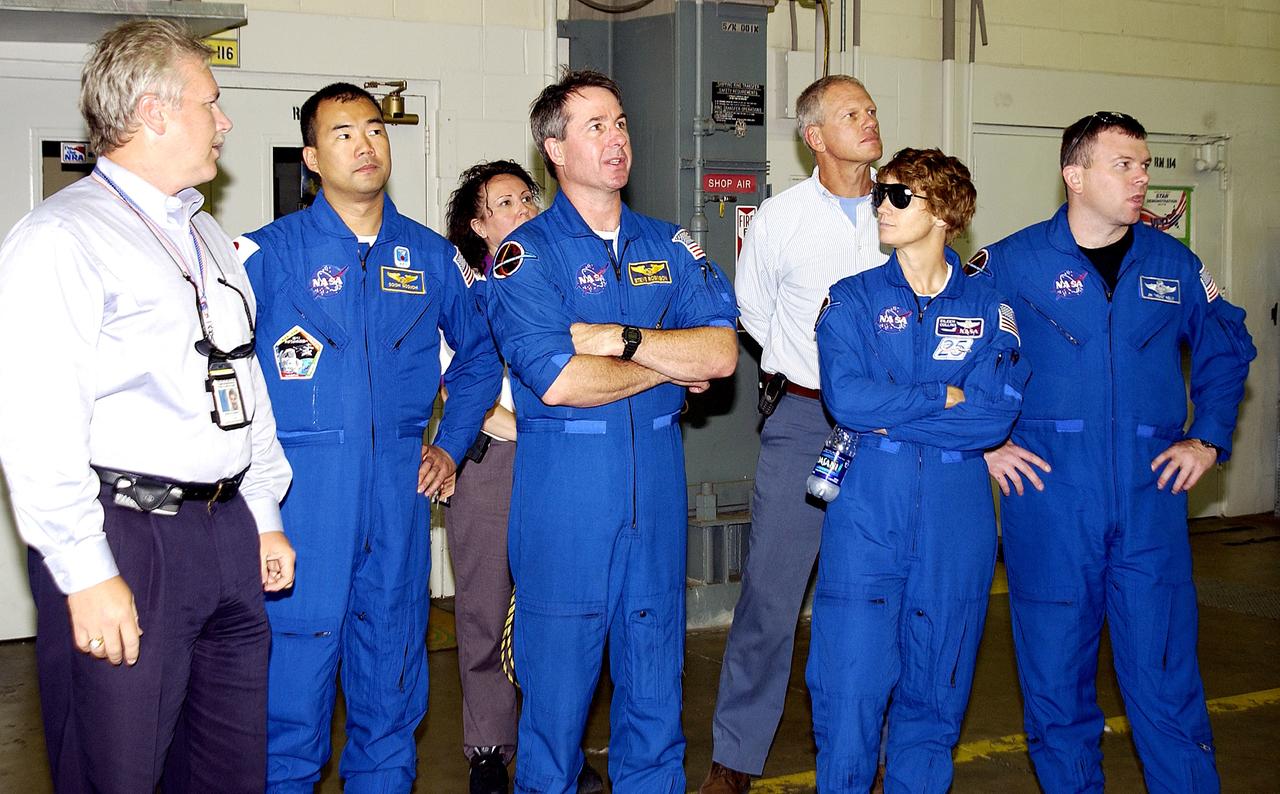 KENNEDY SPACE CENTER, FLA. -  In Hangar AF, Cape Canaveral Air Force Station, the STS-114 crew look at equipment used to disassemble and refurbish solid rocket boosters retrieved after a Shuttle launch.  Starting second from left are Mission Specialist Soichi Noguchi, Mission Specialist Stephen Robinson, Commander Eileen Collins, and Pilot James Kelly. Noguchi is with the Japanese space agency NASDA.  At far left is Joseph Chaput, with United Space Alliance. On their mission, the crew will carry the MultiPurpose Logistics Module (MPLM) Raffaello and External Stowage Platform 2 to the International Space Station.  The MPLM will contain supplies and equipment.  Another goal of the mission is to remove and replace a Control Moment Gyro.  Launch date for mission STS-114 is under review.