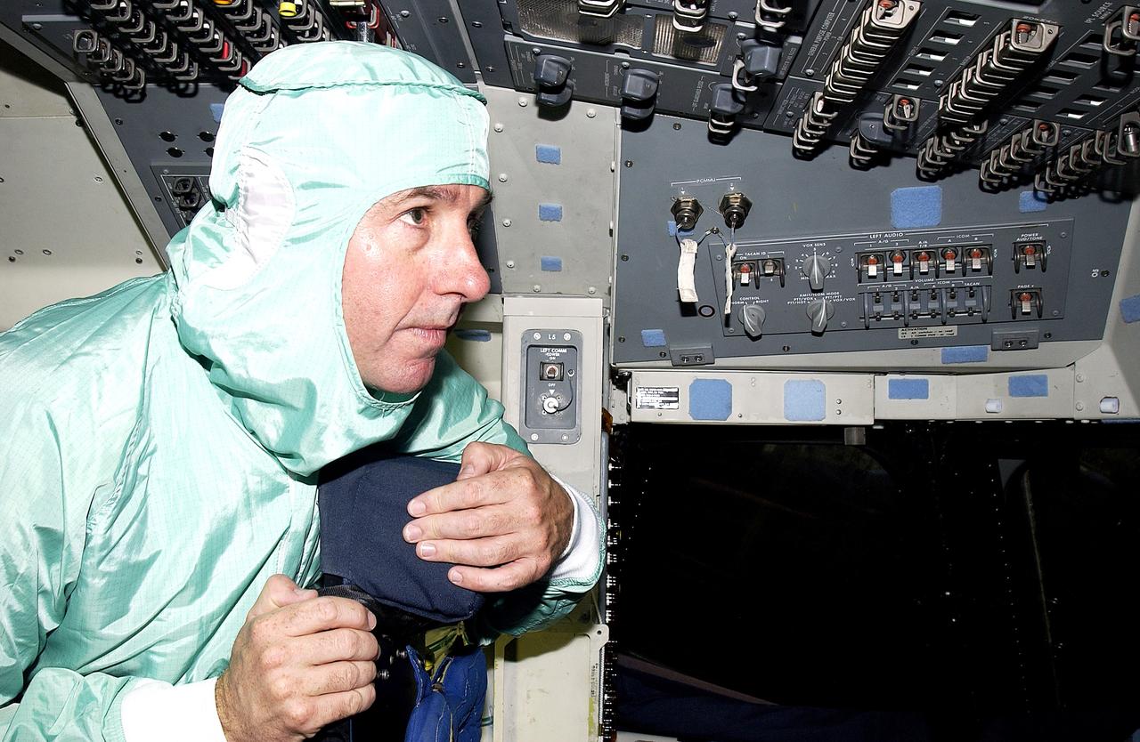 KENNEDY SPACE CENTER, FLA. -   STS-114 Mission Specialist Stephen Robinson looks at equipment in the flight deck of orbiter Atlantis.  He and other crew members -  Commander Eileen Collins, Pilot James Kelly and Mission Specialist Soichi Noguchi - are at KSC for equipment familiarization.  Noguchi is with the Japanese space agency NASDA.  Mission STS-114 will carry the MultiPurpose Logistics Module (MPLM) Raffaello and External Stowage Platform 2 to the International Space Station.  The MPLM will contain supplies and equipment.  Another goal of the mission is to remove and replace a Control Moment Gyro.  Launch date for mission STS-114 is under review.