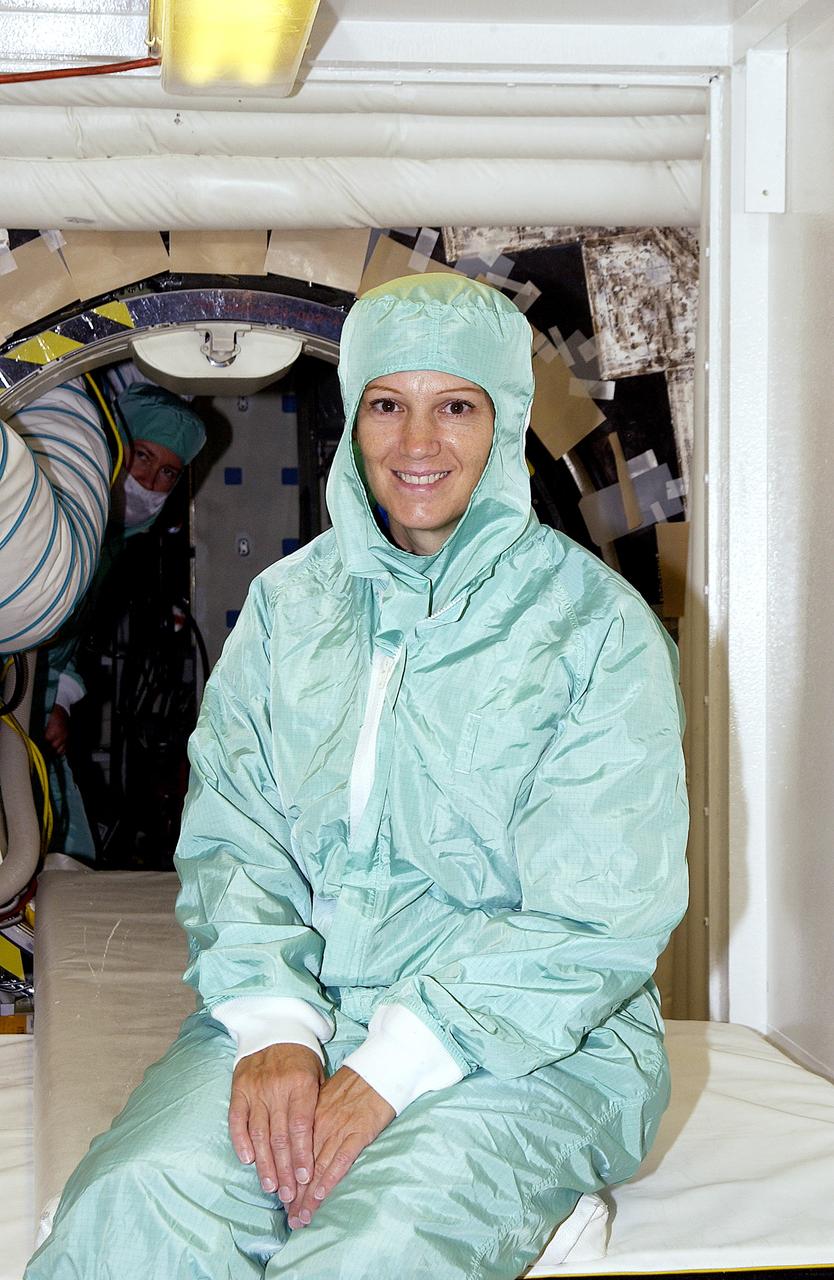 KENNEDY SPACE CENTER, FLA. -  STS-114 Commander Eileen Collins sits in the entry hatch to orbiter Atlantis.  She and other crew members - Pilot James Kelly and  Mission Specialists Soichi Noguchi and Stephen Robinson -  are at KSC for equipment familiarization. Noguchi is with the Japanese space agency NASDA. Mission STS-114 will carry the MultiPurpose Logistics Module (MPLM) Raffaello and External Stowage Platform 2 to the International Space Station.  The MPLM will contain supplies and equipment.  Another goal of the mission is to remove and replace a Control Moment Gyro.  Launch date for mission STS-114 is under review.