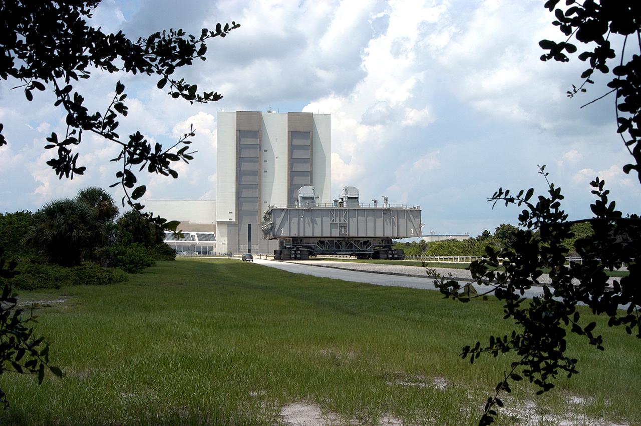 KENNEDY SPACE CENTER, FLA.  -Crawler-transporter (CT) number 2, moves away from the Vehicle Assembly Building, with a Mobile Launcher Platform on top, on a test run to the launch pad.  The CT recently underwent modifications to the cab.  The CT moves Space Shuttle vehicles between the VAB and launch pad.  Moving on four double-tracked crawlers, the CT uses a laser guidance system and a leveling system for the journey that keeps the top of a Space Shuttle vertical within plus- or minus-10 minutes of arc.  The system enables the CT-MLP-Shuttle to negotiate the ramp leading to the launch pads and keep the load level.  Unloaded, the CT weighs 6 million pounds.