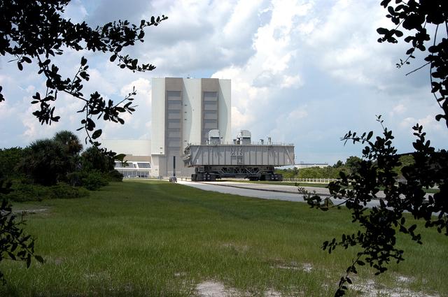KENNEDY SPACE CENTER, FLA.  -Crawler-transporter (CT) number 2, moves away from the Vehicle Assembly Building, with a Mobile Launcher Platform on top, on a test run to the launch pad.  The CT recently underwent modifications to the cab.  The CT moves Space Shuttle vehicles between the VAB and launch pad.  Moving on four double-tracked crawlers, the CT uses a laser guidance system and a leveling system for the journey that keeps the top of a Space Shuttle vertical within plus- or minus-10 minutes of arc.  The system enables the CT-MLP-Shuttle to negotiate the ramp leading to the launch pads and keep the load level.  Unloaded, the CT weighs 6 million pounds.