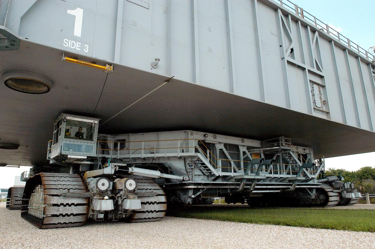 KENNEDY SPACE CENTER, FLA.  -  A closeup of crawler-transporter (CT) number 2 shows the cab (left, above the tracks) that recently underwent modifications.  The CT is transporting a Mobile Launch Platform (MLP) on a test run to the pad.  The CT moves Space Shuttle vehicles, situated on the MLP, between the VAB and launch pad.  Moving on four double-tracked crawlers, the CT uses a laser guidance system and a leveling system for the journey that keeps the top of a Space Shuttle vertical within plus- or minus-10 minutes of arc.  The system enables the CT-MLP-Shuttle to negotiate the ramp leading to the launch pads and keep the load level.  Unloaded, the CT weighs 6 million pounds.  Seen on top of the MLP are two tail service masts that support the fluid, gas and electrical requirements of the orbiter’s liquid oxygen and liquid hydrogen aft umbilicals.