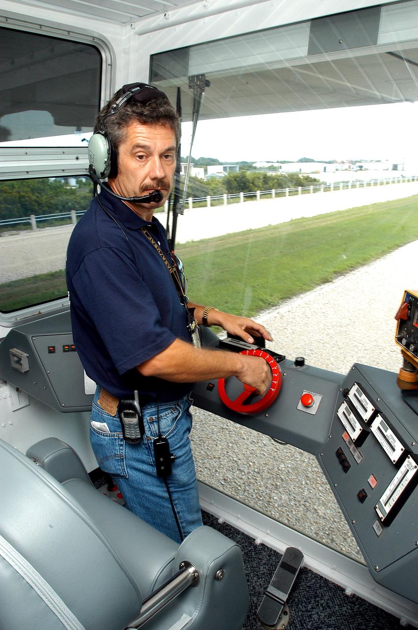 KENNEDY SPACE CENTER, FLA.  -  Inside the cab of crawler-transporter (CT) number 2, driver Sam Dove, with United Space Alliance, operates the vehicle on a test run to the launch pad.  The CT recently underwent modifications to the cab.   The CT is transporting a Mobile Launch Platform (MLP).  The CT moves Space Shuttle vehicles, situated on the MLP, between the VAB and launch pad.  Moving on four double-tracked crawlers, the CT uses a laser guidance system and a leveling system for the journey that keeps the top of a Space Shuttle vertical within plus- or minus-10 minutes of arc.  The system enables the CT-MLP-Shuttle to negotiate the ramp leading to the launch pads and keep the load level.  Unloaded, the CT weighs 6 million pounds.  Seen on top of the MLP are two tail service masts that support the fluid, gas and electrical requirements of the orbiter’s liquid oxygen and liquid hydrogen aft umbilicals.