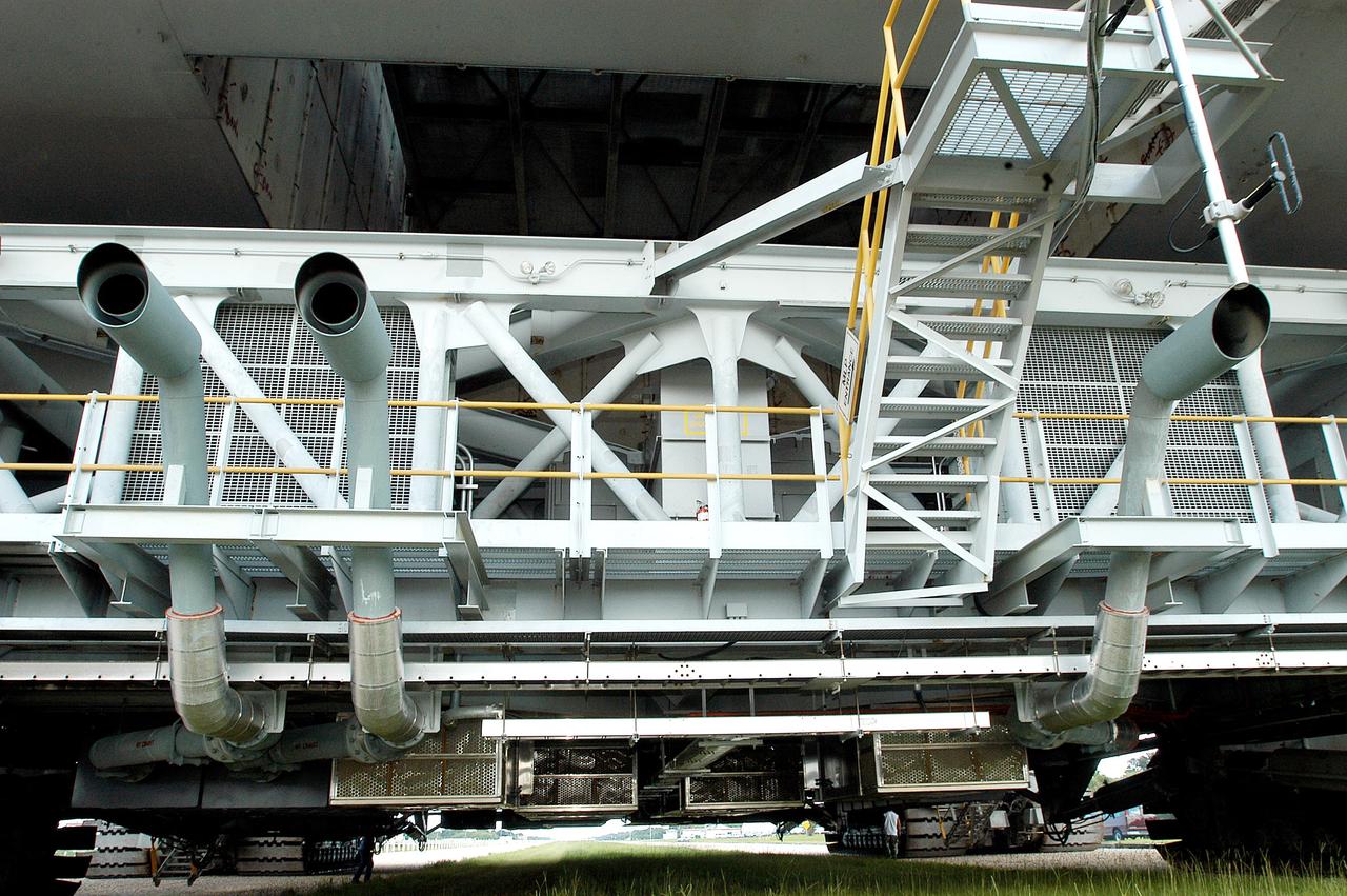 KENNEDY SPACE CENTER, FLA.  -  A closeup of crawler-transportation (CT) number 2 shows the new muffler system on the vehicle.  The CT also recently underwent modifications to the cab.   The CT is transporting a Mobile Launch Platform (MLP).  The CT moves Space Shuttle vehicles, situated on the MLP, between the VAB and launch pad.  Moving on four double-tracked crawlers, the CT uses a laser guidance system and a leveling system for the journey that keeps the top of a Space Shuttle vertical within plus- or minus-10 minutes of arc.  The system enables the CT-MLP-Shuttle to negotiate the ramp leading to the launch pads and keep the load level.  Unloaded, the CT weighs 6 million pounds.  Seen on top of the MLP are two tail service masts that support the fluid, gas and electrical requirements of the orbiter’s liquid oxygen and liquid hydrogen aft umbilicals.