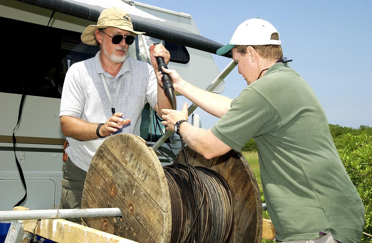 KENNEDY SPACE CENTER, FLA.  -  Research team members work with acoustic cable during underwater acoustic research being conducted in the Launch Complex 39 turn basin.  Several government agencies, including NASA, NOAA, the Navy, the Coast Guard, and the Florida Fish and Wildlife Commission are involved in the testing. The research involves demonstrations of passive and active sensor technologies, with applications in fields ranging from marine biological research to homeland security. The work is also serving as a pilot project to assess the cooperation between the agencies involved. Equipment under development includes a passive acoustic monitor developed by NASA’s Jet Propulsion Laboratory, and mobile robotic sensors from the Navy’s Mobile Diving and Salvage Unit.