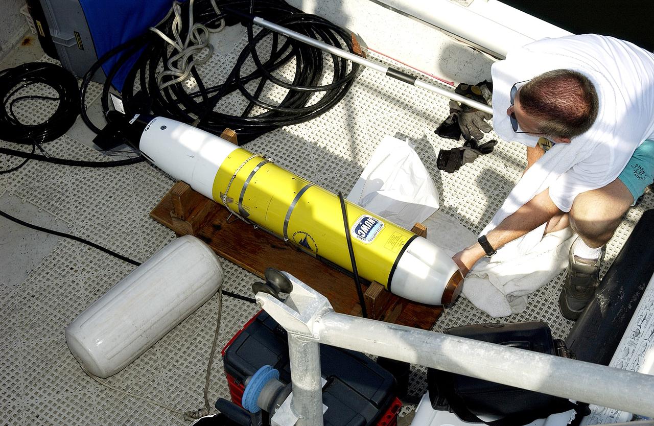 KENNEDY SPACE CENTER, FLA.  -  A research team member aboard one of the watercraft being utilized to conduct underwater acoustic research in the Launch Complex 39 turn basin prepares some of the project's equipment for placement in the water.  Several government agencies, including NASA, NOAA, the Navy, the Coast Guard, and the Florida Fish and Wildlife Commission are involved in the testing. The research involves demonstrations of passive and active sensor technologies, with applications in fields ranging from marine biological research to homeland security. The work is also serving as a pilot project to assess the cooperation between the agencies involved. Equipment under development includes a passive acoustic monitor developed by NASA’s Jet Propulsion Laboratory, and mobile robotic sensors from the Navy’s Mobile Diving and Salvage Unit.
