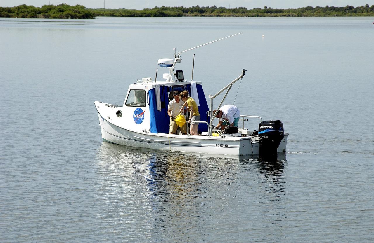 KENNEDY SPACE CENTER, FLA.  -  Research team members aboard one of the watercraft being utilized to conduct underwater acoustic research in the Launch Complex 39 turn basin prepare to release some of the project's equipment into the water.  Several government agencies, including NASA, NOAA, the Navy, the Coast Guard, and the Florida Fish and Wildlife Commission are involved in the testing. The research involves demonstrations of passive and active sensor technologies, with applications in fields ranging from marine biological research to homeland security. The work is also serving as a pilot project to assess the cooperation between the agencies involved. Equipment under development includes a passive acoustic monitor developed by NASA’s Jet Propulsion Laboratory, and mobile robotic sensors from the Navy’s Mobile Diving and Salvage Unit.