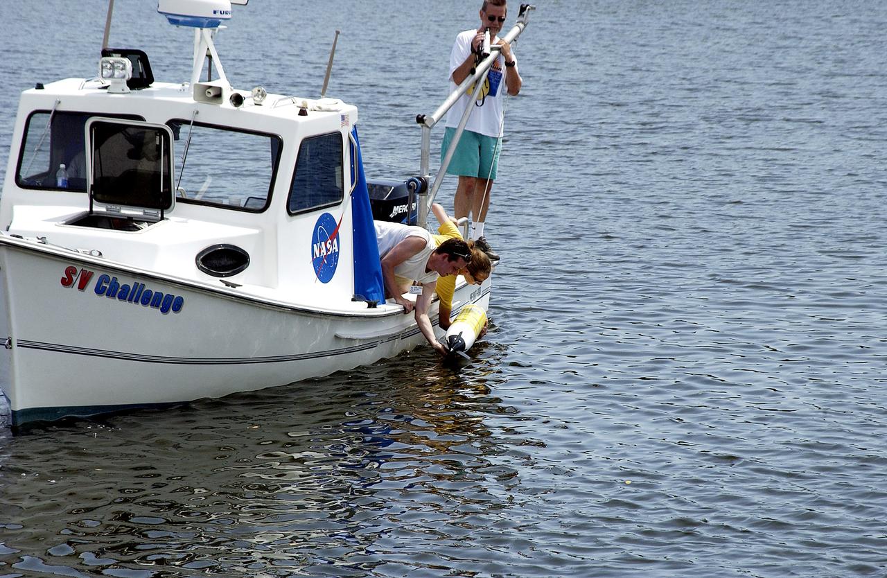 KENNEDY SPACE CENTER, FLA.  -  Research team members aboard one of the watercraft being utilized to conduct underwater acoustic research in the Launch Complex 39 turn basin release some of the project's equipment into the water.  Several government agencies, including NASA, NOAA, the Navy, the Coast Guard, and the Florida Fish and Wildlife Commission are involved in the testing. The research involves demonstrations of passive and active sensor technologies, with applications in fields ranging from marine biological research to homeland security. The work is also serving as a pilot project to assess the cooperation between the agencies involved. Equipment under development includes a passive acoustic monitor developed by NASA’s Jet Propulsion Laboratory, and mobile robotic sensors from the Navy’s Mobile Diving and Salvage Unit.