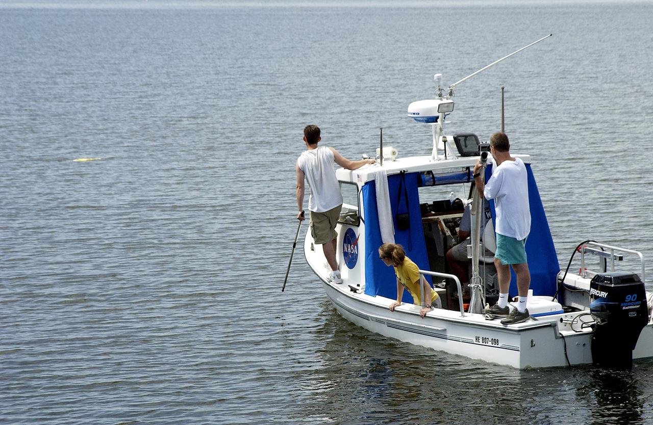 KENNEDY SPACE CENTER, FLA.  -  Research team members aboard one of the watercraft being utilized to conduct underwater acoustic research in the Launch Complex 39 turn basin monitor some of the project's equipment just released into the water.  Several government agencies, including NASA, NOAA, the Navy, the Coast Guard, and the Florida Fish and Wildlife Commission are involved in the testing. The research involves demonstrations of passive and active sensor technologies, with applications in fields ranging from marine biological research to homeland security. The work is also serving as a pilot project to assess the cooperation between the agencies involved. Equipment under development includes a passive acoustic monitor developed by NASA’s Jet Propulsion Laboratory, and mobile robotic sensors from the Navy’s Mobile Diving and Salvage Unit.
