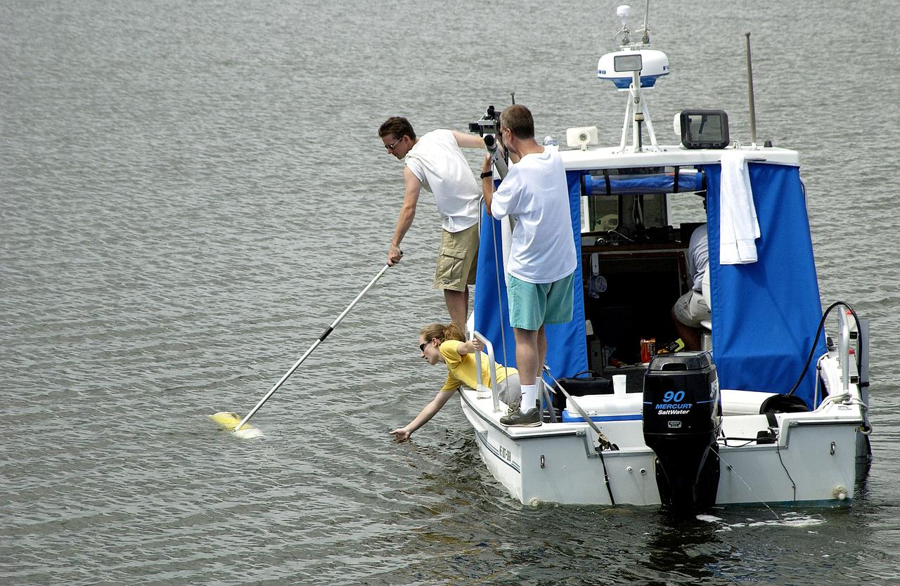 KENNEDY SPACE CENTER, FLA.  -  Research team members aboard one of the watercraft being utilized to conduct underwater acoustic research in the Launch Complex 39 turn basin retrieve some of the project's equipment from the water.  Several government agencies, including NASA, NOAA, the Navy, the Coast Guard, and the Florida Fish and Wildlife Commission are involved in the testing. The research involves demonstrations of passive and active sensor technologies, with applications in fields ranging from marine biological research to homeland security. The work is also serving as a pilot project to assess the cooperation between the agencies involved. Equipment under development includes a passive acoustic monitor developed by NASA’s Jet Propulsion Laboratory, and mobile robotic sensors from the Navy’s Mobile Diving and Salvage Unit.
