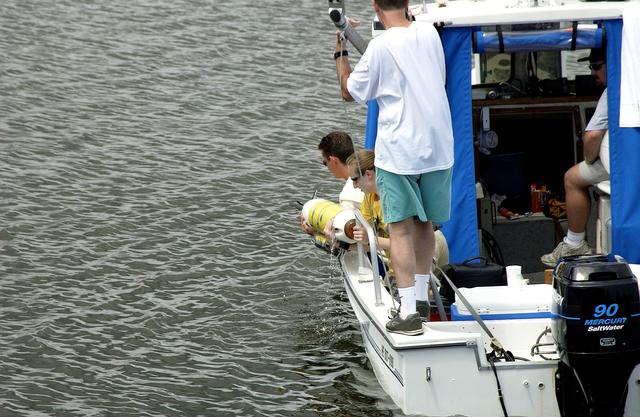 NASA image: KENNEDY SPACE CENTER, FLA.  -  A research team member aboard one of the watercraft being utilized to conduct underwater acoustic research in the Launch Complex 39 turn basin lifts some of the project's equipment from the water.  Several government agencies, including NASA, NOAA, the Navy, the Coast Guard, and the Florida Fish and Wildlife Commission are involved in the testing. The research involves demonstrations of passive and active sensor technologies, with applications in fields ranging from marine biological research to homeland security. The work is also serving as a pilot project to assess the cooperation between the agencies involved. Equipment under development includes a passive acoustic monitor developed by NASA’s Jet Propulsion Laboratory, and mobile robotic sensors from the Navy’s Mobile Diving and Salvage Unit.