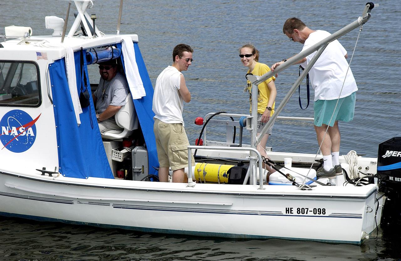 KENNEDY SPACE CENTER, FLA.  -  Research team members aboard one of the watercraft being utilized to conduct underwater acoustic research in the Launch Complex 39 turn basin secure some of the project's equipment back into the vessel.  Several government agencies, including NASA, NOAA, the Navy, the Coast Guard, and the Florida Fish and Wildlife Commission are involved in the testing. The research involves demonstrations of passive and active sensor technologies, with applications in fields ranging from marine biological research to homeland security. The work is also serving as a pilot project to assess the cooperation between the agencies involved. Equipment under development includes a passive acoustic monitor developed by NASA’s Jet Propulsion Laboratory, and mobile robotic sensors from the Navy’s Mobile Diving and Salvage Unit.