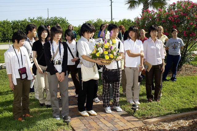 NASA image: KENNEDY SPACE CENTER, FLA.  -   Japanese girls from Urawa Daiichi Girls High School, Urawa, Japan, carry a floral tribute to the crew of Columbia to place at the STS-107 memorial stone at the Spacehab facility, Cape Canaveral, Fla.   The group was  awarded the trip to Florida when their experiments were chosen to fly on mission STS-107.  The group was also meeting with American students from Melbourne and Jacksonville, Fla.   The National Space Development  Agency of Japan (NASDA) and the KSC International Space Station and Payloads Processing Directorate worked with the NASA KSC Education Programs and University Research Division to coordinate the students’ visit.