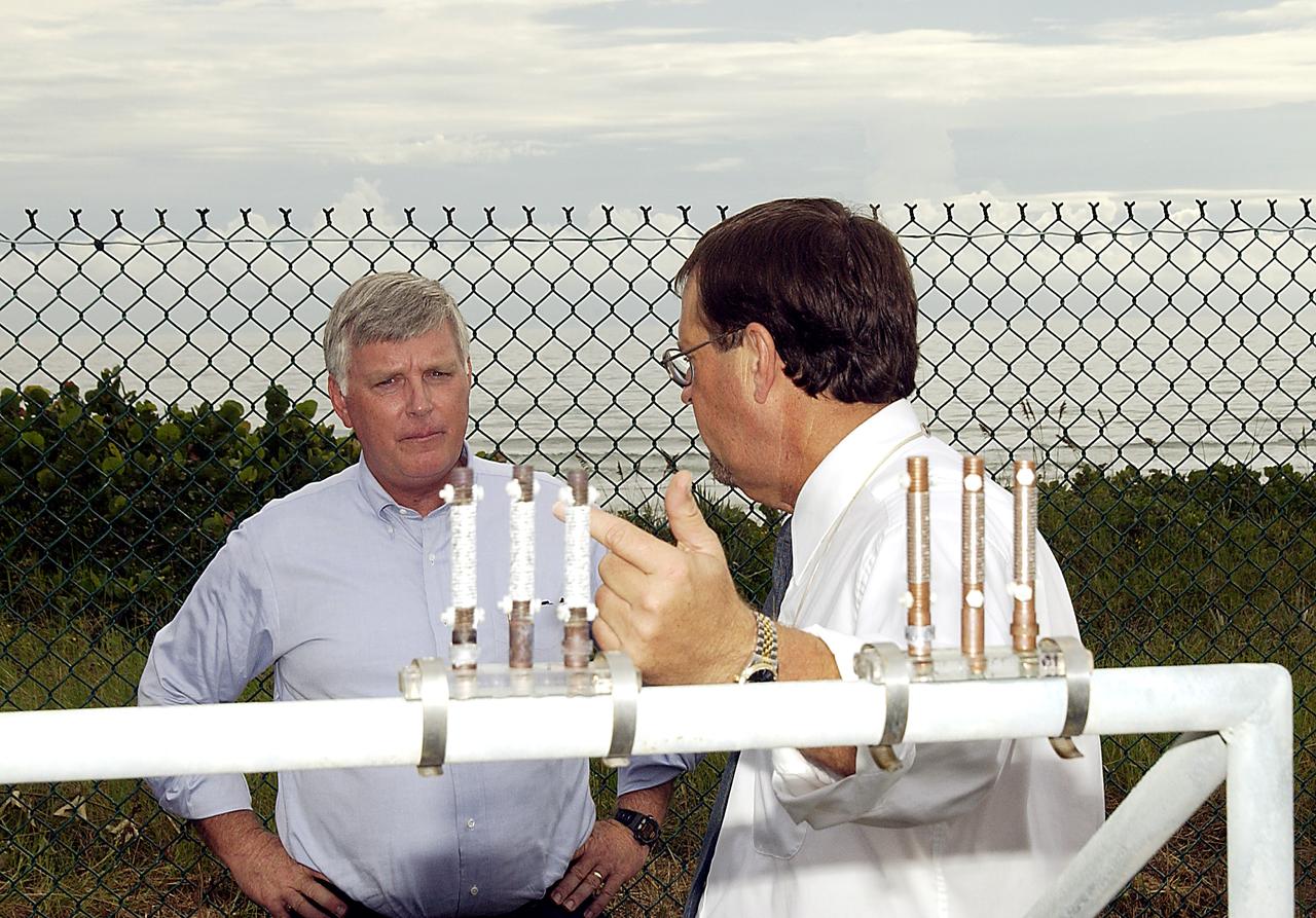 KENNEDY SPACE CENTER, FLA. -    Louis MacDowell (right), Testbed manager, explains to Center Director Jim Kennedy the use of astmospheric calibration specimens.  Placed at various locations, they can rank the corrosivity of the given environment.  The KSC Beach Corrosion Test Site was established in the 1960s and has provided more than 30 years of historical information on the long-term performance of many materials in use at KSC and other locations around the world. Located 100 feet from the Atlantic Ocean approximately 1 mile south of the Space Shuttle launch sites, the test facility includes an atmospheric exposure site, a flowing seawater exposure site, and an on-site electrochemistry laboratory and monitoring station. The beach laboratory is used to conduct real-time corrosion experiments and provides for the remote monitoring of surrounding weather conditions. The newly added flowing seawater immersion facility provides for the immersion testing of materials and devices under controlled conditions.