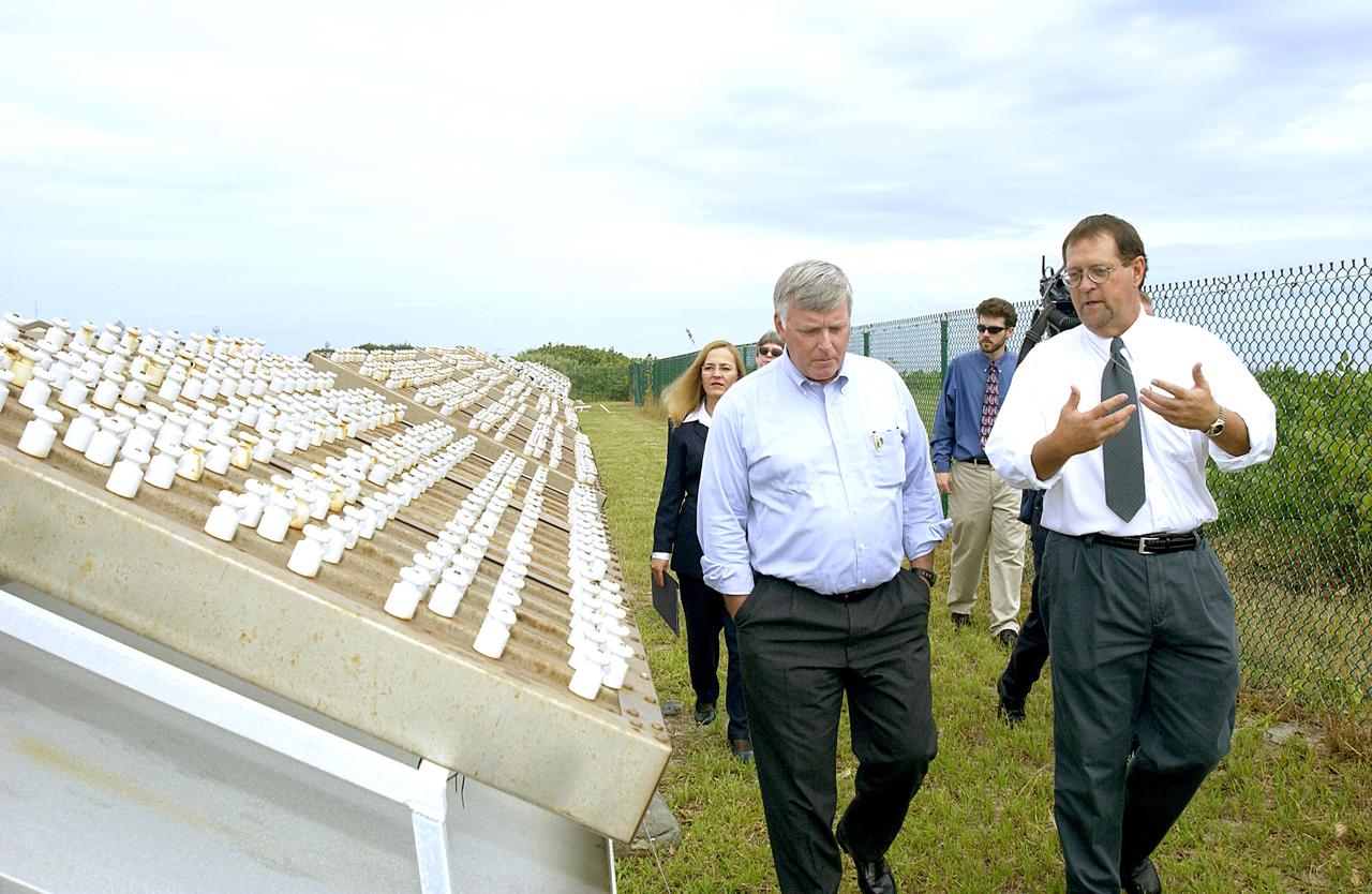 KENNEDY SPACE CENTER, FLA. -   On a tour of the KSC Beach Corrosion Test Site, Louis MacDowell (right), Testbed manager, explains to Center Director Jim Kennedy a project being undertaken for the U.S. Navy.  At left are nonchrome primers for aircraft being studied.  Behind Kennedy is Lead Scientist Dr. Luz Marina Calle.  Behind MacDowell is Dr. Paul Hintze, who is working on a graduate project for the National Research Council.  The KSC Beach Corrosion Test Site was established in the 1960s and has provided more than 30 years of historical information on the long-term performance of many materials in use at KSC and other locations around the world. Located 100 feet from the Atlantic Ocean approximately 1 mile south of the Space Shuttle launch sites, the test facility includes an atmospheric exposure site, a flowing seawater exposure site, and an on-site electrochemistry laboratory and monitoring station. The beach laboratory is used to conduct real-time corrosion experiments and provides for the remote monitoring of surrounding weather conditions. The newly added flowing seawater immersion facility provides for the immersion testing of materials and devices under controlled conditions.