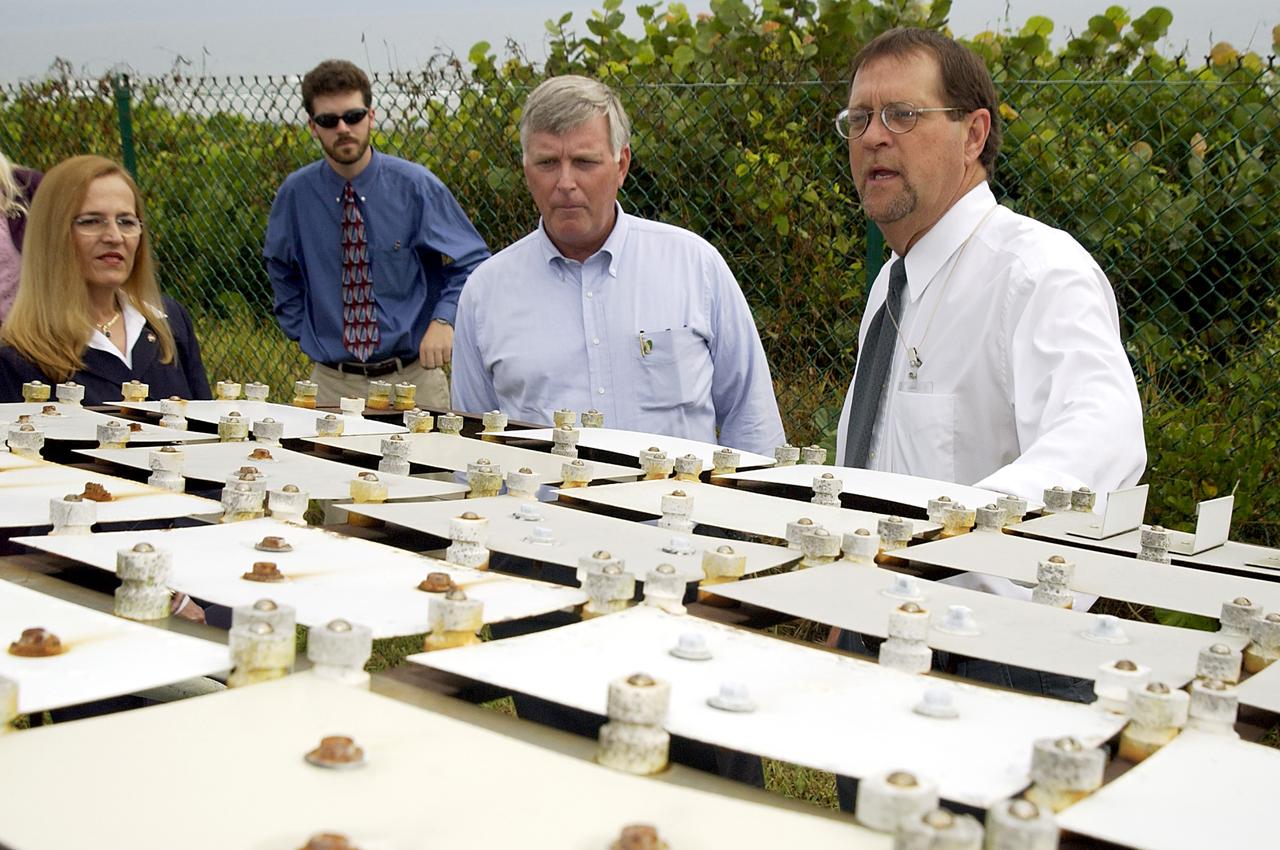 KENNEDY SPACE CENTER, FLA. -   On a tour of the KSC Beach Corrosion Test Site, Center Director Jim Kennedy (second from right) learns from Testbed Manager Louis MacDowell (right) about a project being undertaken for the U.S. Navy.  Being studied are nonchrome primers for aircraft.  At left are Lead Scientist Dr. Luz Marina Calle and  Dr. Paul Hintze, who is working on a graduate project for the National Research Council.  The KSC Beach Corrosion Test Site was established in the 1960s and has provided more than 30 years of historical information on the long-term performance of many materials in use at KSC and other locations around the world. Located 100 feet from the Atlantic Ocean approximately 1 mile south of the Space Shuttle launch sites, the test facility includes an atmospheric exposure site, a flowing seawater exposure site, and an on-site electrochemistry laboratory and monitoring station. The beach laboratory is used to conduct real-time corrosion experiments and provides for the remote monitoring of surrounding weather conditions. The newly added flowing seawater immersion facility provides for the immersion testing of materials and devices under controlled conditions.