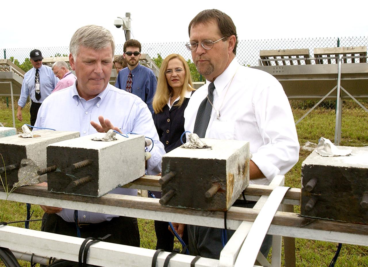 KENNEDY SPACE CENTER, FLA. -   On a tour of the KSC Beach Corrosion Test Site, Testbed Manager Louis MacDowell (right) explains to Center Director Jim Kennedy about the test blocks being used to test a newly developed coating to protect steel inside concrete.  Between MacDowell and Kennedy are Dr. Paul Hintze and Lead Scientist Dr. Luz Marina Calle.  The KSC Beach Corrosion Test Site was established in the 1960s and has provided more than 30 years of historical information on the long-term performance of many materials in use at KSC and other locations around the world. Located 100 feet from the Atlantic Ocean approximately 1 mile south of the Space Shuttle launch sites, the test facility includes an atmospheric exposure site, a flowing seawater exposure site, and an on-site electrochemistry laboratory and monitoring station. The beach laboratory is used to conduct real-time corrosion experiments and provides for the remote monitoring of surrounding weather conditions. The newly added flowing seawater immersion facility provides for the immersion testing of materials and devices under controlled conditions.