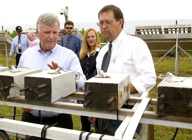 NASA image: KENNEDY SPACE CENTER, FLA. -   On a tour of the KSC Beach Corrosion Test Site, Testbed Manager Louis MacDowell (right) explains to Center Director Jim Kennedy about the test blocks being used to test a newly developed coating to protect steel inside concrete.  Between MacDowell and Kennedy are Dr. Paul Hintze and Lead Scientist Dr. Luz Marina Calle.  The KSC Beach Corrosion Test Site was established in the 1960s and has provided more than 30 years of historical information on the long-term performance of many materials in use at KSC and other locations around the world. Located 100 feet from the Atlantic Ocean approximately 1 mile south of the Space Shuttle launch sites, the test facility includes an atmospheric exposure site, a flowing seawater exposure site, and an on-site electrochemistry laboratory and monitoring station. The beach laboratory is used to conduct real-time corrosion experiments and provides for the remote monitoring of surrounding weather conditions. The newly added flowing seawater immersion facility provides for the immersion testing of materials and devices under controlled conditions.