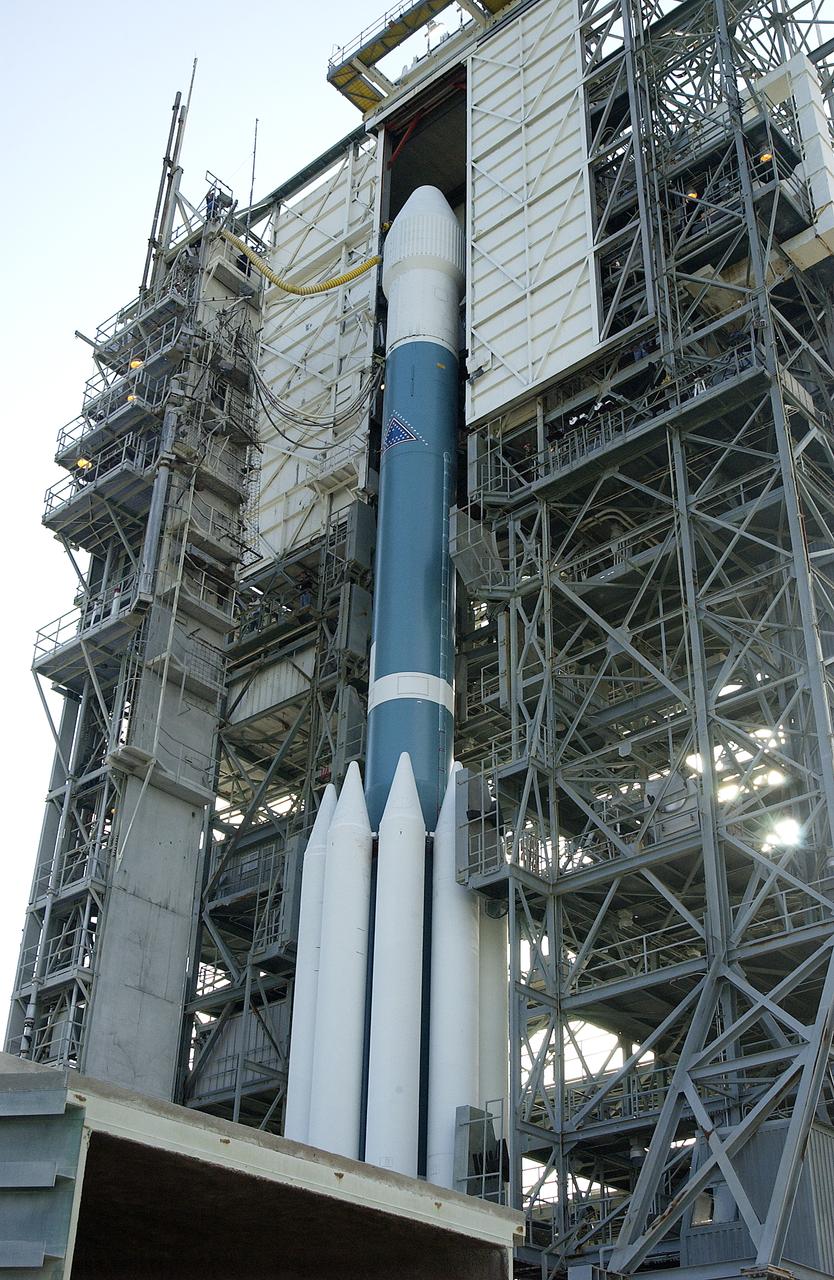 The mobile service tower is rolled back at Launch Pad 17-B, Cape Canaveral Air Force Station, to reveal NASA's Space Infrared Telescope Facility (SIRTF) ready for launch aboard a Delta II Heavy launch vehicle. Liftoff is scheduled for Aug. 25 at 1:35:39 a.m. EDT. SIRTF will obtain images and spectra by detecting the infrared energy, or heat, radiated by objects in space. Consisting of a 0.85-meter telescope and three cryogenically cooled science instruments, SIRTF will be the largest infrared telescope ever launched into space. It is the fourth and final element in NASA’s family of orbiting “Great Observatories.” Its highly sensitive instruments will give a unique view of the Universe and peer into regions of space that are hidden from optical telescopes.