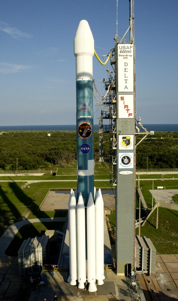 The mobile service tower is rolled back at Launch Pad 17-B, Cape Canaveral Air Force Station, to reveal NASA's Space Infrared Telescope Facility (SIRTF) ready for launch aboard a Delta II Heavy launch vehicle. Liftoff is scheduled for Aug. 25 at 1:35:39 a.m. EDT. SIRTF will obtain images and spectra by detecting the infrared energy, or heat, radiated by objects in space. Consisting of a 0.85-meter telescope and three cryogenically cooled science instruments, SIRTF will be the largest infrared telescope ever launched into space. It is the fourth and final element in NASA’s family of orbiting “Great Observatories.” Its highly sensitive instruments will give a unique view of the Universe and peer into regions of space that are hidden from optical telescopes.