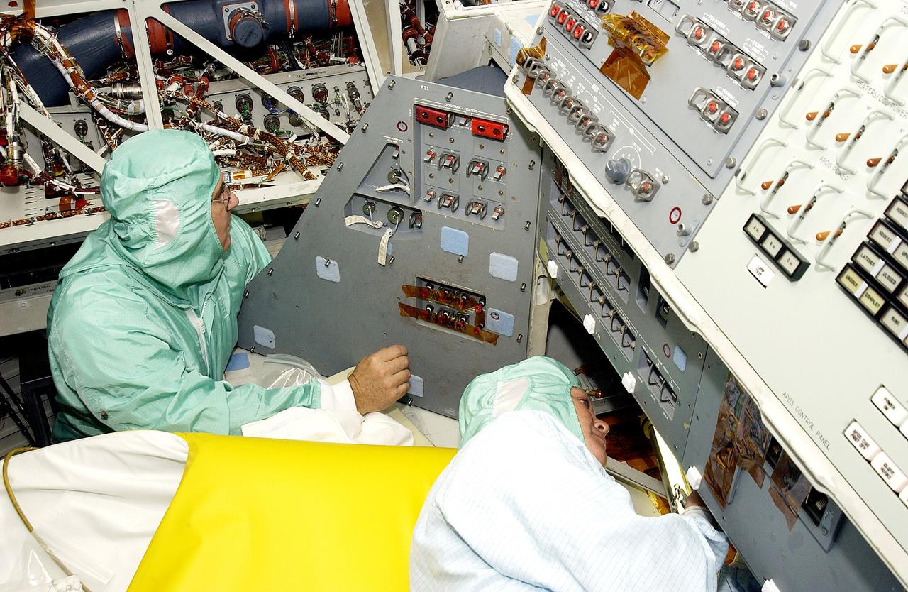 KENNEDY SPACE CENTER, FLA.  -     Technicians with United Space Alliance work in close quarters as they check the wiring on the mid-body of orbiter Atlantis.  The inspection is part of routine maintenance.