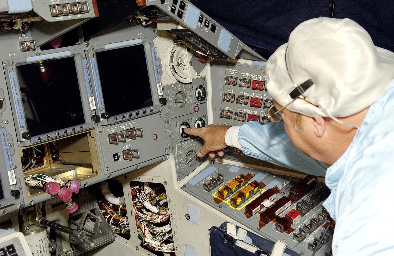 KENNEDY SPACE CENTER, FLA.  -   During power-up of the orbiter Discovery in the Orbiter Processing Facility, a technician turns on a switch.  Discovery has been undergoing Orbiter Major Modifications in the past year, ranging from wiring, control panels and black boxes to gaseous and fluid systems tubing and components.  These systems were deserviced, disassembled, inspected, modified, reassembled, checked out and reserviced, as were most other systems onboard.  The work includes the installation of the Multifunction Electronic Display Subsystem (MEDS) - a state-of-the-art “glass cockpit.”