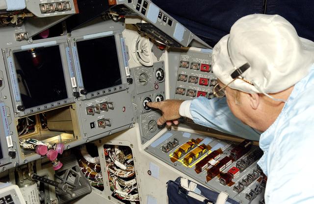 NASA image: KENNEDY SPACE CENTER, FLA.  -   During power-up of the orbiter Discovery in the Orbiter Processing Facility, a technician turns on a switch.  Discovery has been undergoing Orbiter Major Modifications in the past year, ranging from wiring, control panels and black boxes to gaseous and fluid systems tubing and components.  These systems were deserviced, disassembled, inspected, modified, reassembled, checked out and reserviced, as were most other systems onboard.  The work includes the installation of the Multifunction Electronic Display Subsystem (MEDS) - a state-of-the-art “glass cockpit.”