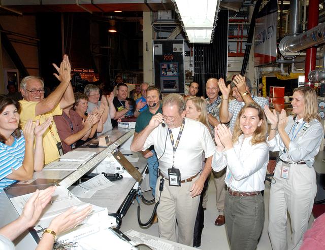 NASA image: KENNEDY SPACE CENTER, FLA.  -   In the Orbiter Processing Facility, the processing team applaud the successful power-up of the orbiter Discovery.  The vehicle has been undergoing Orbiter Major Modifications in the past year, ranging from wiring, control panels and black boxes to gaseous and fluid systems tubing and components.  These systems were deserviced, disassembled, inspected, modified, reassembled, checked out and reserviced, as were most other systems onboard.  The work includes the installation of the Multifunction Electronic Display Subsystem (MEDS) - a state-of-the-art “glass cockpit.”