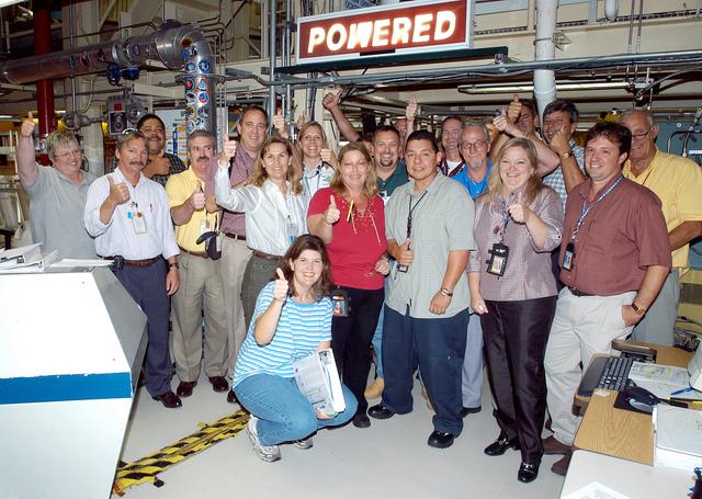 NASA image: KENNEDY SPACE CENTER, FLA.  -  In the Orbiter Processing Facility, the processing team celebrates the  successful power-up of the orbiter Discovery.  The vehicle has been undergoing Orbiter Major Modifications in the past year, ranging from wiring, control panels and black boxes to gaseous and fluid systems tubing and components.  These systems were deserviced, disassembled, inspected, modified, reassembled, checked out and reserviced, as were most other systems onboard.  The work includes the installation of the Multifunction Electronic Display Subsystem (MEDS) - a state-of-the-art “glass cockpit.”