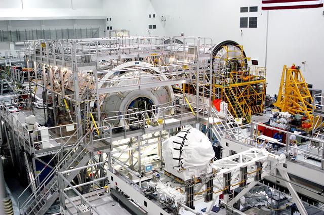 NASA image: KENNEDY SPACE CENTER, FLA. - In the Space Station Processing Facility, the U.S. Node 2 (center) and the Japanese Experiment Module (JEM), background right, await a Multi-Element Integrated Test (MEIT). Node 2 attaches to the end of the U.S. Lab on the International Space Station and provides attach locations for the Japanese laboratory, European laboratory, the Centrifuge Accommodation Module and, eventually, Multipurpose Logistics Modules. It will provide the primary docking location for the Shuttle when a pressurized mating adapter is attached to Node 2.  Installation of the module will complete the U.S. Core of the ISS.  The National Space Development Agency of Japan (NASDA) developed their laboratory at the Tsukuba Space Center near Tokyo. It is the first element, named "Kibo" (Hope), to be delivered to KSC. The JEM is Japan's primary contribution to the Station. It will enhance the unique research capabilities of the orbiting complex by providing an additional environment for astronauts to conduct science experiments.