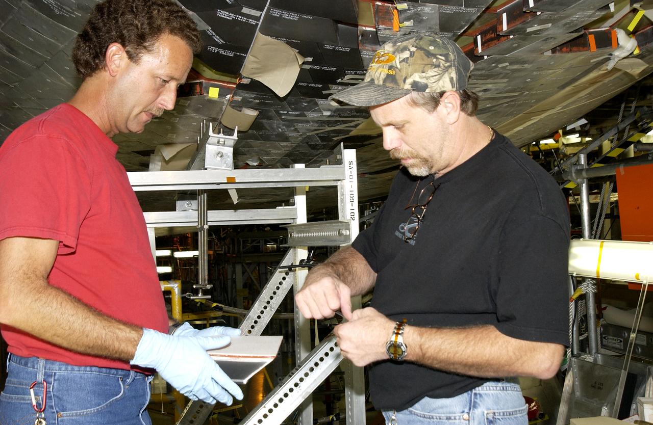 In the Vehicle Assembly Building, Jim Landy, NDE specialist, sets up a flight crew lockers for flash thermography. He is screening the lockers for hidden damage underneath dings and dents that might occur during handling.