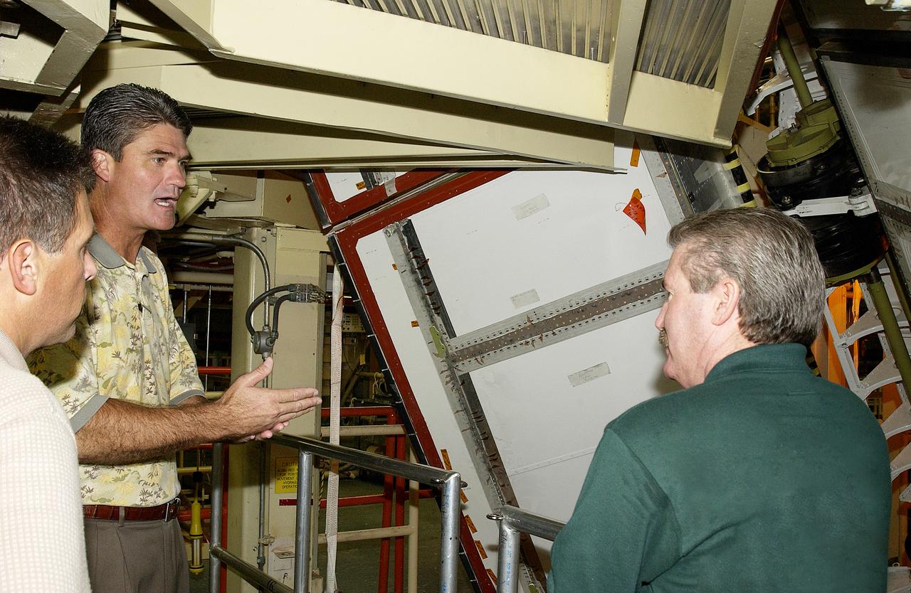 Mark McGee (right) shows the bead blasting completed on the rudder speed brake on orbiter Discovery to Shuttle Program Manager Bill Parsons (center). McGee is manager, Orbiter Processing Facility, with United Space Alliance. At left is Mark Nappi, deputy associate program manager, ground operations, USA. The work was part of Orbiter Major Modifications (OMM) that were recently completed on Discovery. The OMM work ranged from wiring, control panels and black boxes to gaseous and fluid systems tubing and components. These systems were deserviced, disassembled, inspected, modified, reassembled, checked out and reserviced, as were most other systems onboard. The work included the installation of the Multifunction Electronic Display Subsystem (MEDS) - a state-of-the-art “glass cockpit.”