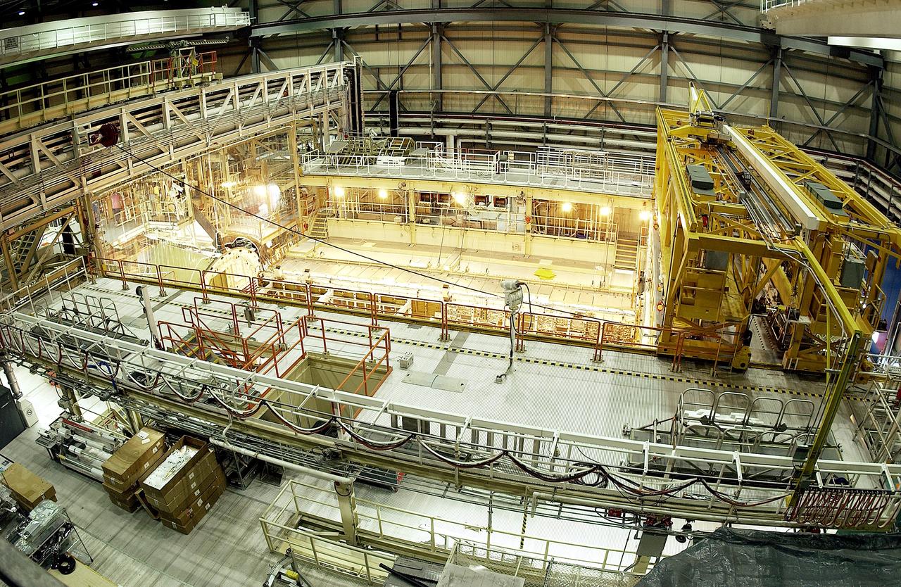 KENNEDY SPACE CENTER, FLA. -  This bird's-eye view of a high bay in the Orbiter Processing Facility (OPF) shows the open payload bay of Space Shuttle Discovery surrounded by the standard platforms and equipment required to process a Space Shuttle orbiter.  The high bay is 197 feet (60 meters) long, 150 feet (46 meters) wide, 95 feet (29 meters) high, and encompasses a 29,000-square-foot (2,694-meter) area.  The 30-ton (27-metric-ton) bridge crane (yellow device, right) has a hook height of approximately 66 feet (20 meters).  Platforms, a main access bridge, and two rolling bridges with trucks provide access to various parts of the orbiter.  In addition to routine servicing and checkout, the inspections and modifications made to enhance Discovery's performance and upgrade its systems were performed in the OPF during its recently completed Orbiter Major Modification (OMM) period.