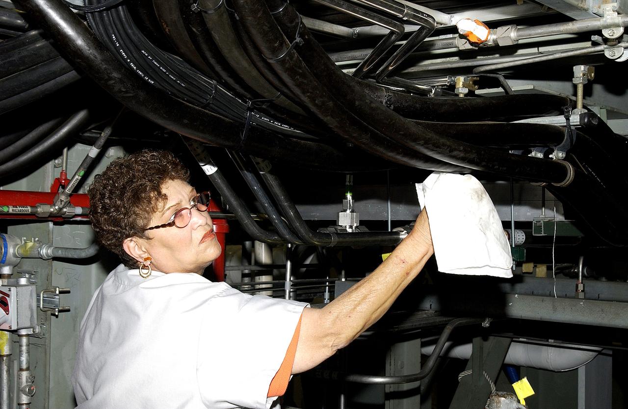 KENNEDY SPACE CENTER, FLA. - A KSC employee wipes down some of the hoses of the ground support equipment in the Orbiter Processing Facility (OPF) where Space Shuttle Atlantis is being processed for flight.  Preparations are under way for the next launch of Atlantis on mission STS-114, a utilization and logistics flight to the International Space Station.