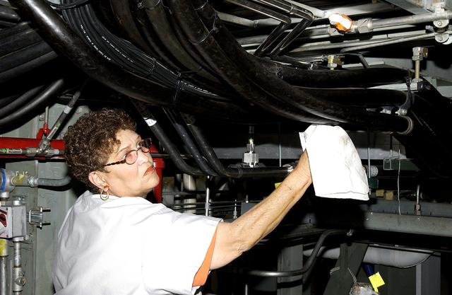 KENNEDY SPACE CENTER, FLA. - A KSC employee wipes down some of the hoses of the ground support equipment in the Orbiter Processing Facility (OPF) where Space Shuttle Atlantis is being processed for flight.  Preparations are under way for the next launch of Atlantis on mission STS-114, a utilization and logistics flight to the International Space Station.
