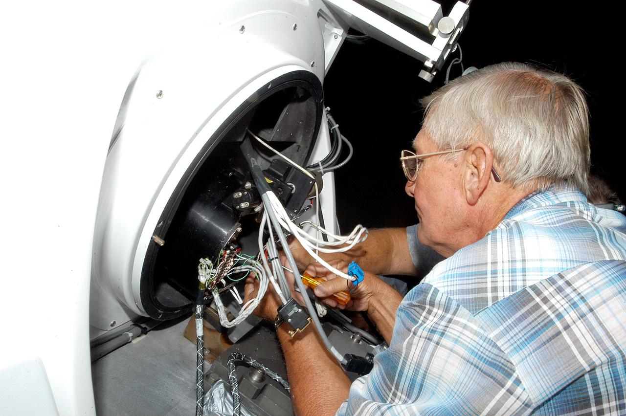 KENNEDY SPACE CENTER, FLA. - A worker calibrates a tracking telescope, part of the Distant Object Attitude Measurement System (DOAMS),  located in Cocoa Beach, Fla.  The telescope provides optical support for launches from KSC and Cape Canaveral.