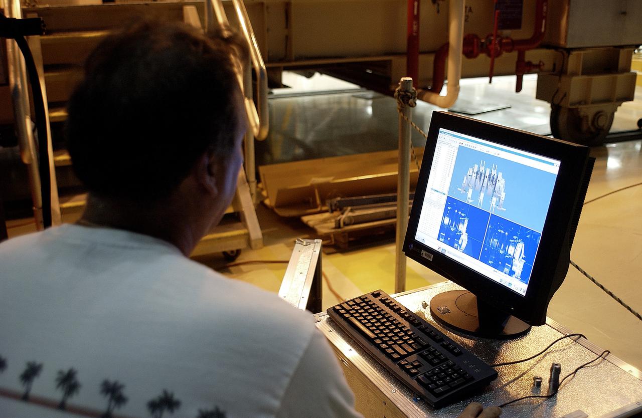 KENNEDY SPACE CENTER, FLA. -  In the Orbiter Processing Facility, Boeing worker Alden Pitard looks at a 3D digital scan of an actuator.  There are two actuators per engine on the Shuttle, one for pitch motion and one for yaw motion. The Space Shuttle Main Engine hydraulic servoactuators are used to gimbal the main engine.