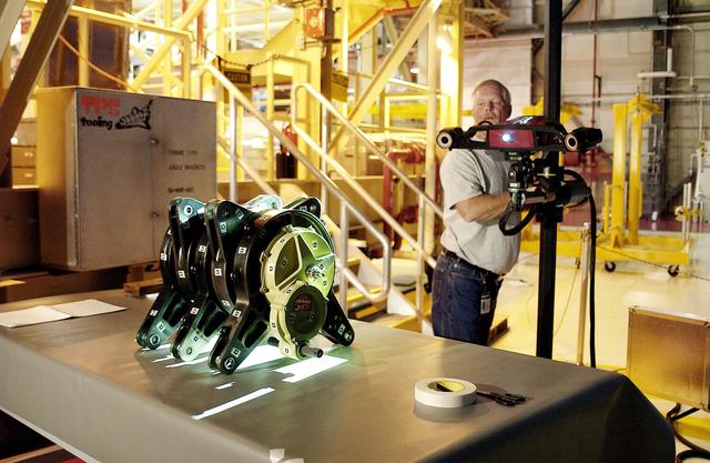 NASA image: KENNEDY SPACE CENTER, FLA. - In the Orbiter Processing Facility,  Dan Clark, with KSC Boeing, operates the camera for a 3D digital scan of the actuator on the table.  There are two actuators per engine on the Shuttle, one for pitch motion and one for yaw motion. The Space Shuttle Main Engine hydraulic servoactuators are used to gimbal the main engine.