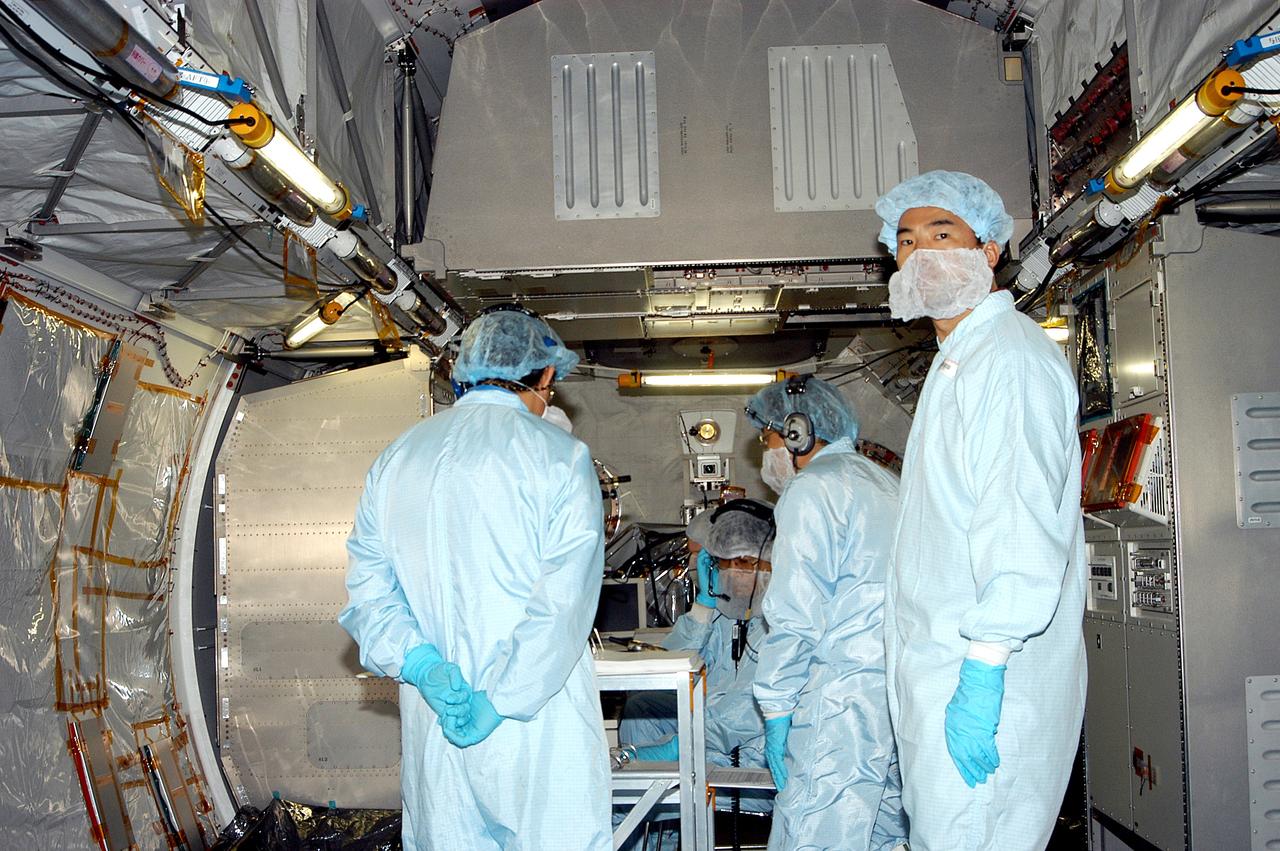 KENNEDY SPACE CENTER, FLA. -   Astronaut Soichi Noguchi (right), with the National Space Development Agency of Japan (NASDA), is inside the Japanese Experiment Module (JEM), undergoing a Multi-Element Integrated Test (MEIT)  in the Space Station Processing Facility.  Noguchi is assigned to mission STS-114 as a mission specialist.   Node 2 attaches to the end of the U.S. Lab on the ISS and provides attach locations for the Japanese laboratory, European laboratory, the Centrifuge Accommodation Module and, eventually, Multipurpose Logistics Modules. It will provide the primary docking location for the Shuttle when a pressurized mating adapter is attached to Node 2.  Installation of the module will complete the U.S. Core of the ISS.   The JEM, developed by NASDA,  is Japan's primary contribution to the Station. It will enhance the unique research capabilities of the orbiting complex by providing an additional environment for astronauts to conduct science experiments.