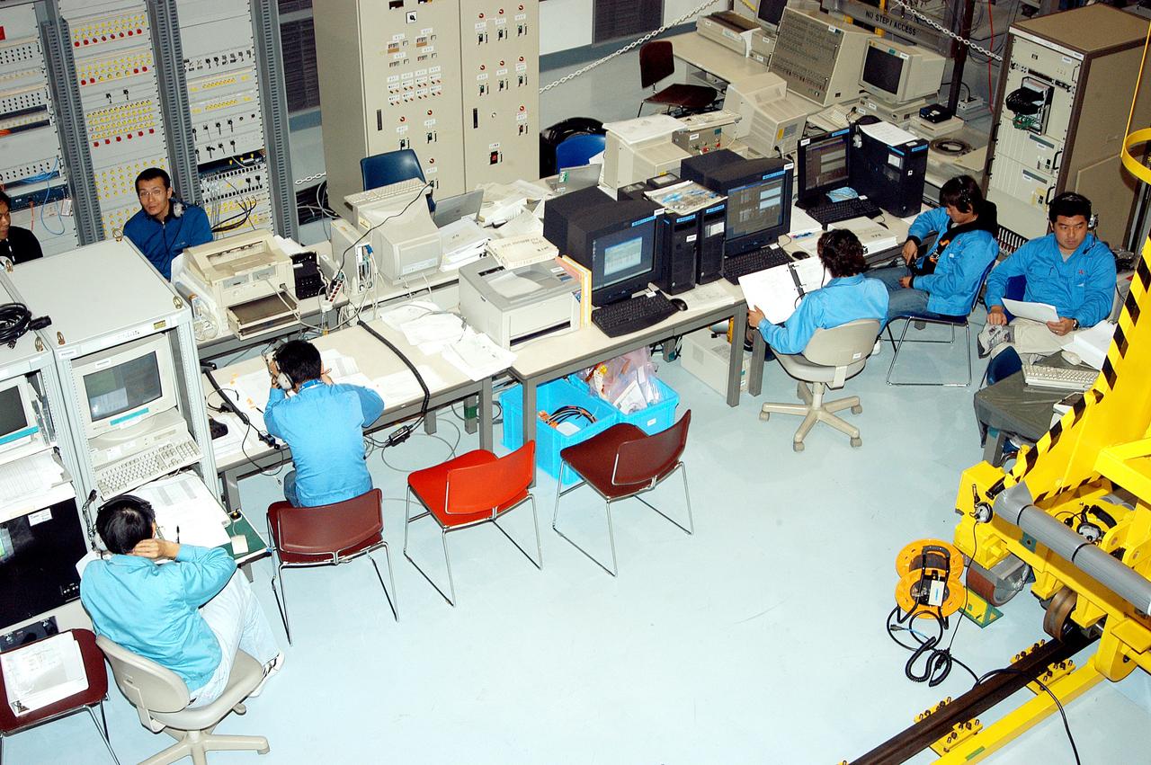 KENNEDY SPACE CENTER, FLA. -  Workers in the Space Station Processing Facility are lined up at consoles during  a Multi-Element Integrated Test (MEIT ) of the Japanese Experiment Module (JEM) and U.S. Node 2.  Node 2 attaches to the end of the U.S. Lab on the ISS and provides attach locations for the Japanese laboratory, European laboratory, the Centrifuge Accommodation Module and, eventually, Multipurpose Logistics Modules. It will provide the primary docking location for the Shuttle when a pressurized mating adapter is attached to Node 2.  Installation of the module will complete the U.S. Core of the ISS.   The JEM, developed by NASDA,  is Japan's primary contribution to the Station. It will enhance the unique research capabilities of the orbiting complex by providing an additional environment for astronauts to conduct science experiments.