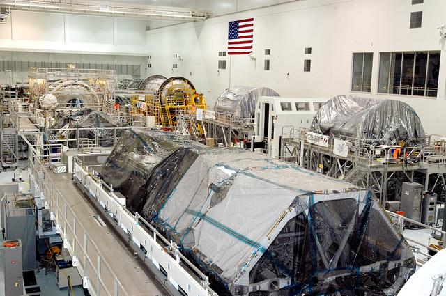 NASA image: KENNEDY SPACE CENTER, FLA. -  Various elements intended for the International Space Station are lined up in the Space Station Processing Facility.  The newest to arrive at KSC are in the rear: at left, the U.S. Node 2, and next to it at right, the Japanese Experiment Module (JEM).  The two elements are undergoing a Multi-Element Integrated Test (MEIT).   Node 2 attaches to the end of the U.S. Lab on the ISS and provides attach locations for the Japanese laboratory, European laboratory, the Centrifuge Accommodation Module and, eventually, Multipurpose Logistics Modules. It will provide the primary docking location for the Shuttle when a pressurized mating adapter is attached to Node 2.  Installation of the module will complete the U.S. Core of the ISS.   Developed by the National Space Development Agency of Japan (NASDA), the JEM is Japan's primary contribution to the Station. It will enhance the unique research capabilities of the orbiting complex by providing an additional environment for astronauts to conduct science experiments.