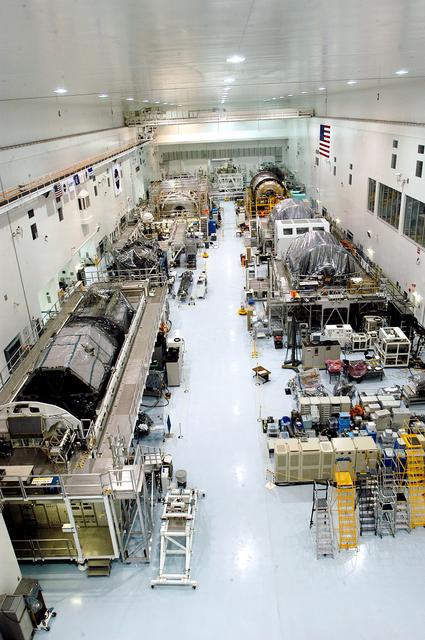 NASA image: KENNEDY SPACE CENTER, FLA. -  Various elements intended for the International Space Station are lined up in the Space Station Processing Facility.  The newest to arrive at KSC are in the rear: at left, the U.S. Node 2, and next to it at right, the Japanese Experiment Module (JEM).  The two elements are undergoing a Multi-Element Integrated Test (MEIT).   Node 2 attaches to the end of the U.S. Lab on the ISS and provides attach locations for the Japanese laboratory, European laboratory, the Centrifuge Accommodation Module and, eventually, Multipurpose Logistics Modules. It will provide the primary docking location for the Shuttle when a pressurized mating adapter is attached to Node 2.  Installation of the module will complete the U.S. Core of the ISS.   Developed by the National Space Development Agency of Japan (NASDA), the JEM is Japan's primary contribution to the Station. It will enhance the unique research capabilities of the orbiting complex by providing an additional environment for astronauts to conduct science experiments.