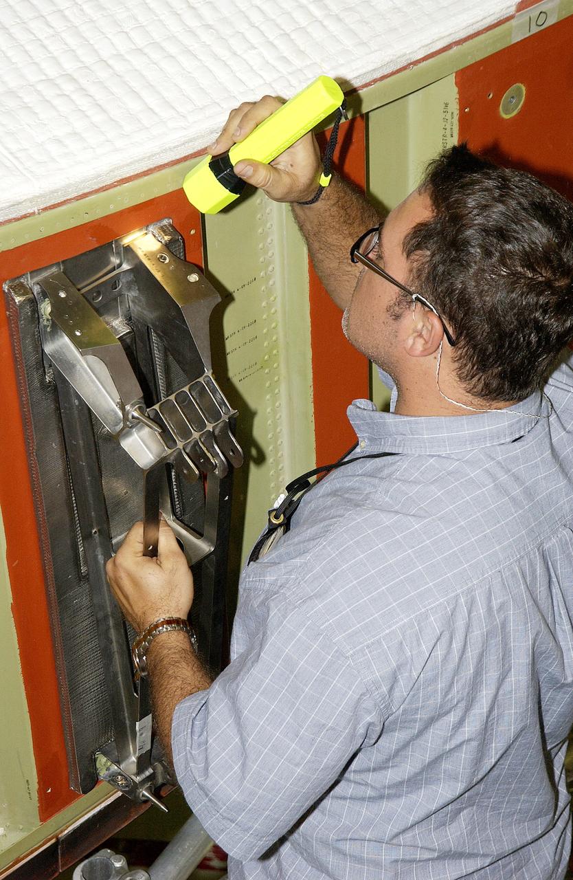 KENNEDY SPACE CENTER, FLA. - In the Orbiter Processing Facility, John Newport, with United Space Alliance, inspects spar installation on the wing of the orbiter Atlantis.  Reinforced Carbon Carbon (RCC) panels are mechanically attached to the wing with a series of floating joints - spars - to reduce loading on the panels caused by wing deflections. The aluminum and the metallic attachments are protected from exceeding temperature limits by internal insulation.