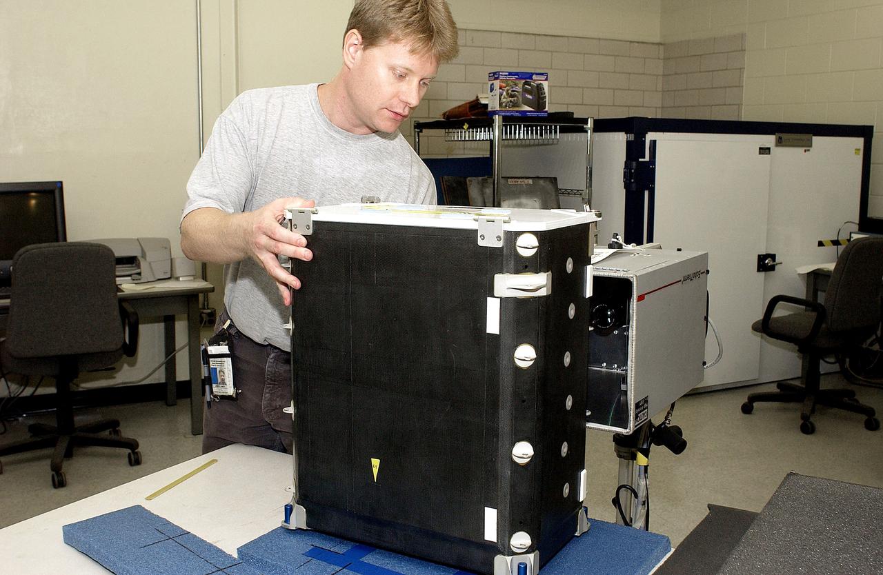 KENNEDY SPACE CENTER, FLA. - In the Vehicle Assembly Building, Jim Landy, NDE specialist, sets up a flight crew lockers for flash thermography.  He is screening the lockers for hidden damage underneath dings and dents that might occur during handling.