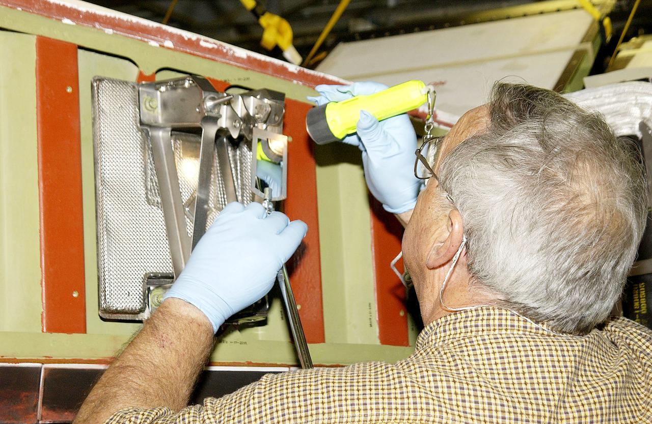 KENNEDY SPACE CENTER, FLA. - In the Orbiter Processing Facility, Jerry Belt, with United Space Alliance, checks a spar attachment on the wing of the orbiter Atlantis before installing Reinforced Carbon Carbon (RCC) panels on the wing.  The spars - floating joints - reduce loading on the panels caused by wing deflections.  The gray carbon composite RCC panels have sufficient strength to withstand the aerodynamic forces experienced during launch and reentry, which can reach as high as 800 pounds per square foot.  The operating range of RCC is from minus 250º F to about 3,000º F, the temperature produced by friction with the atmosphere during reentry.