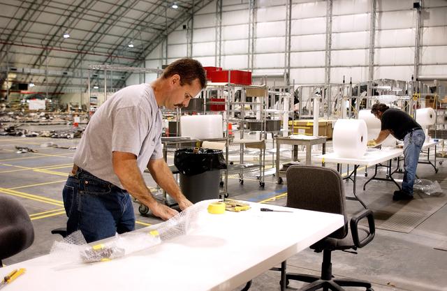 KENNEDY SPACE CENTER, FLA. -In the Columbia Debris Hangar, Don Eitel (left) wraps pieces of Columbia debris for storage.  About 83,000 pieces of debris were shipped to KSC during search and recovery efforts in East Texas. That represents about 38 percent of the dry weight of Columbia, equaling almost 85,000 pounds.  An area of the Vehicle Assembly Building is being prepared to store the debris.