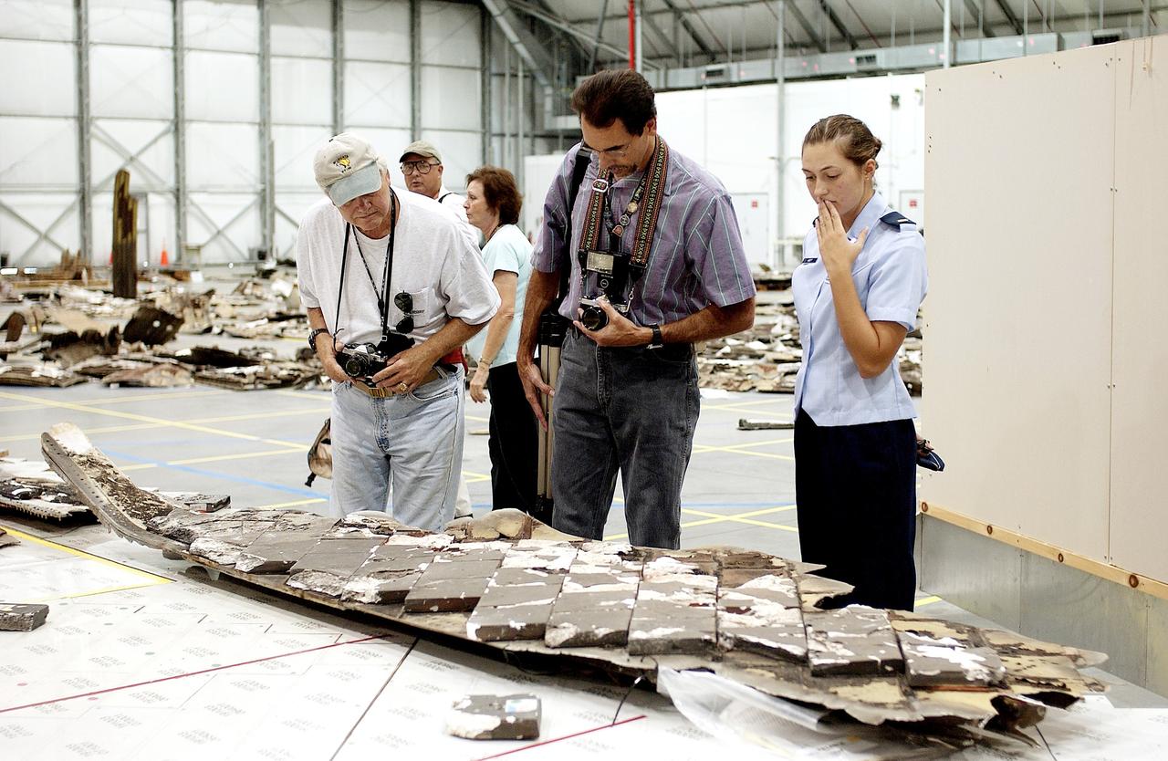 KENNEDY SPACE CENTER, FLA. - During a media tour of the Columbia Debris Hangar, photographers look at pieces of tile collected during search and recovery efforts in East Texas.  About 83,000 pieces of debris from Columbia were shipped to KSC, which represents about 38 percent of the dry weight of Columbia, equaling almost 85,000 pounds.  The debris is being packaged for storage in an area of the Vehicle Assembly Building.