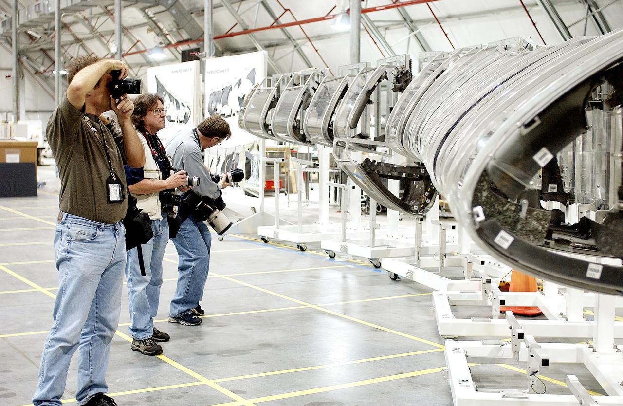 KENNEDY SPACE CENTER, FLA. - During a media tour of the Columbia Debris Hangar, photographers pause at the mockup of the leading edge of Columbia’s left wing.  About 83,000 pieces of debris from Columbia were shipped to KSC from search and recovery efforts in East Texas.  About 83,000 pieces of debris were shipped to KSC, which represents about 38 percent of the dry weight of Columbia, equaling almost 85,000 pounds.  The debris is being packaged for storage in an area of the Vehicle Assembly Building.
