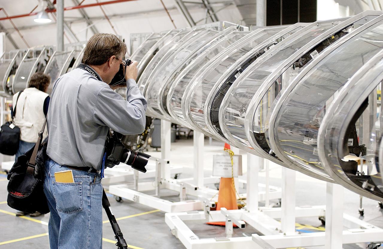 KENNEDY SPACE CENTER, FLA. - During a media tour of the Columbia Debris Hangar, a photographer gets a close-up of the mockup of the leading edge of Columbia’s left wing.  About 83,000 pieces of debris were shipped to KSC from search and recovery efforts in East Texas.  About 83,000 pieces of debris from Columbia were shipped to KSC, which represents about 38 percent of the dry weight of Columbia, equaling almost 85,000 pounds.  The debris is being packaged for storage in an area of the Vehicle Assembly Building.